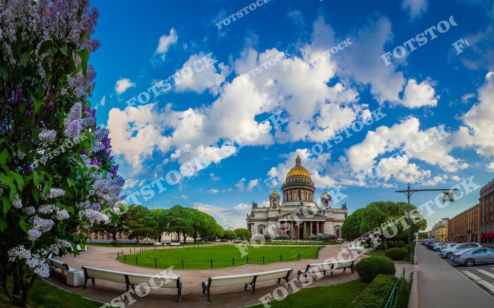 Фотография летнего Санкт-Петербурга с видом на величественный Исаакиевский собор и Исаакиевскую площадь в центре города. Солнечный свет подчеркивает архитектурные детали собора, создавая яркий и впечатляющий городской пейзаж. На снимке видны исторические здания, широкая площадь и туристические маршруты, передающие атмосферу оживленного центра Петербурга. Изображение отлично подходит для туристических публикаций, коллекций фотографий города, постеров и сувенирной продукции, раскрывая красоту архитектуры и уникальную атмосферу летнего Петербурга.